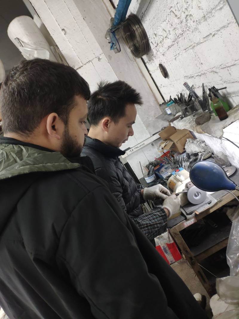 Technical instructor adjusting the tufting gun on an auto tufting machine for consistent pile texture